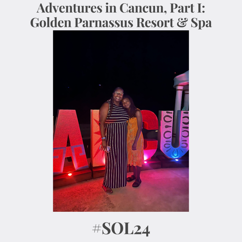 me and my daughter standing shoulder to shoulder in front of part of a Cancun sign: on the left I'm wearing a black and white striped dress; one on the right is my daughter wearing an orange sundress